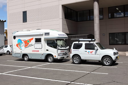 宮城県薬剤師会モバイルファーマシーと支援車両。支援車両は、モバイルファーマシーの先導、設置地周辺における物資と薬剤師移動を担う